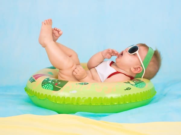 Baby met zonnebril in een zwemband
